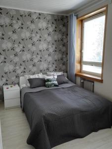 1 dormitorio con 1 cama y papel pintado con motivos florales en Anna Apartment, en Pori
