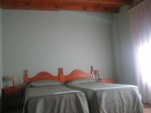 1 dormitorio con 2 camas y ventana en Cal Font (RCP), en Pla de Sant Tirs