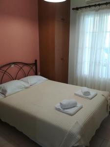 a bedroom with a bed with two towels on it at Konstantina Studios in Agios Nikitas