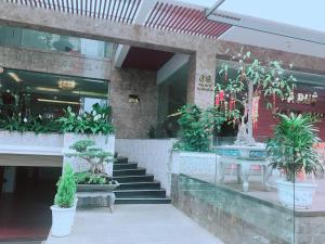 a building with stairs and potted plants in front of it at Hoang Ngoc Hotel in Pleiku