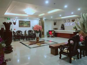 Hoang Ngoc Hotel في بلاي كو: غرفة معيشة مع كراسي وطاولة مع زهور