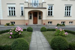 une maison avec des fleurs roses devant elle dans l'établissement Dwór Bieland, à Elbląg