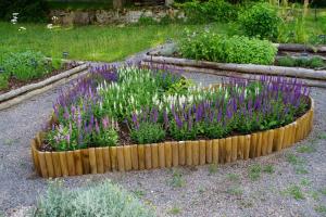 un giardino con fiori e piante viola e bianche di Kloster Neustadt a Neustadt an der Weinstraße