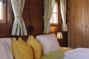 a bedroom with two beds and two windows at Ferienhaus Weberhof in Reith im Alpbachtal