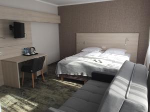 - une chambre avec un lit, un bureau et un canapé dans l'établissement Willa Nest, à Unieście