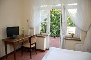 1 dormitorio con escritorio, 1 cama y ventana en Dwór Bieland, en Elbląg