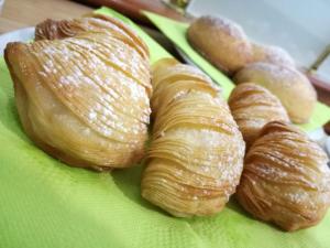 a plate of pastries and croissants on a green napkin at Buono Hotel in Naples