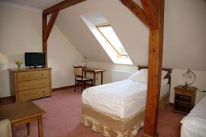 a bedroom with a bed and a desk and a tv at Dwór Bieland in Elblag