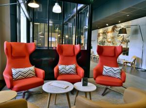 2 chaises et une table dans une salle d'attente dans l'établissement Mercure Périgueux Centre Historique, à Périgueux