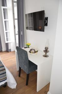 a white dining room table with a chair and a television at Edificio Charles 102 in Funchal