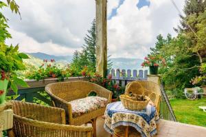 a patio with wicker chairs and a table and a view at villatiffany in Torriglia