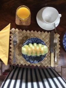 un plato de fruta en una mesa con un vaso de zumo de naranja en Top Parts Bed & Breakfast, en Abbotsbury