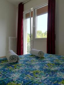 a bed with towels on it with a window at Venice Garden House in Marghera