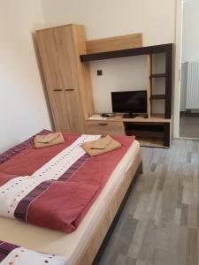 a bedroom with a large bed and a flat screen tv at Kleine Pension in Garstedt