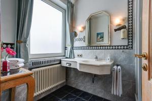 a bathroom with a sink and a window at Hotel Stern by EMPA in Ulm