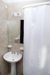 a bathroom with a sink and a shower curtain at Hostel Inn Bariloche in San Carlos de Bariloche