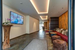 a living room with a red couch and a tv at Centro Hotel Stern in Ulm