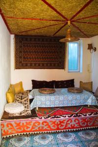 a bedroom with two beds and a window at Osobyi Guest house in Cholpon-Ata