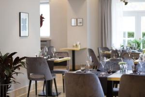 Hotel-Restaurant Beim Schlass في Wiltz: غرفة طعام مع طاولات وكراسي مع كؤوس للنبيذ