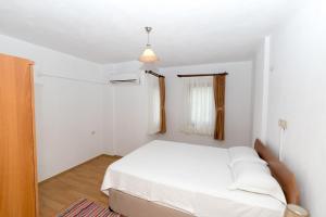 ein weißes Schlafzimmer mit einem Bett und einem Fenster in der Unterkunft Gebora Suits & Tatil Evleri in Palamutbükü