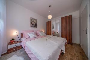 a bedroom with a large bed with pink pillows at Apartment Happy Day in Varaždin