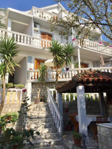 uma casa branca com palmeiras em frente em Apartments Lara em Kotor