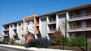 an apartment building with a fence in front of it at City Lodge Appart Hôtel Niort in Niort