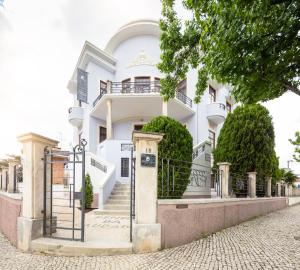a white house with stairs in front of it at Penedo da Saudade Suites & Hostel in Coimbra