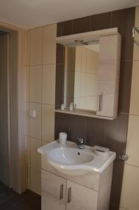 La salle de bains est pourvue d'un lavabo blanc et d'un miroir. dans l'établissement Marianthi Studios, à Áno Meriá