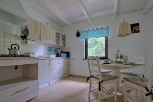 a kitchen with a table and a chair in it at Bajkowy Domek Nad Samym Jeziorem in Narty