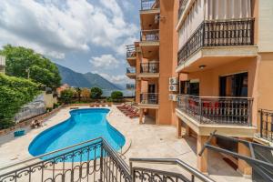 Cet appartement dispose d'un balcon avec une piscine. dans l'établissement Apartments Coral, à Kotor