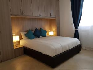 um quarto com uma cama grande e almofadas azuis em L&G's Roof Terrace em Pisa