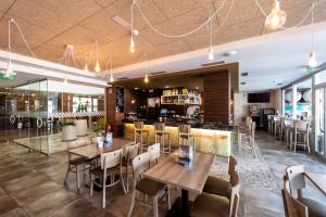 un restaurante con mesas y sillas y un bar en Apartamentos VIDA Mar de Laxe, en Laxe
