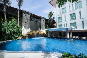 a swimming pool in front of a building at Bintang Kuta Hotel in Kuta