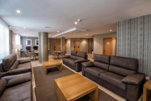 a living room with couches and a dining room at Apartamentos VIDA Mar de Laxe in Laxe