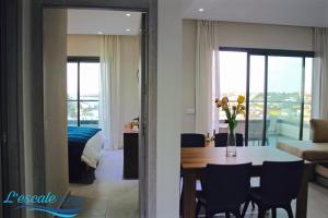 a living room with a dining room table and a bedroom at L'escale Suites Résidence Hôtelière By 7AV HOTELS in Mohammedia