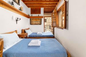 a small room with two beds in a room at Captains House in Lindos