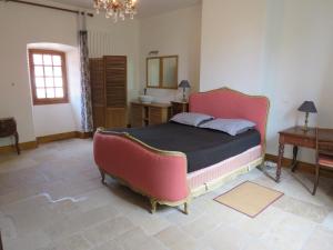 - une chambre avec un lit, une table et un miroir dans l'établissement le presbytère de Montaigut, à Montégut