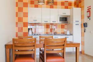 a kitchen with a wooden table and chairs at Alfagar Alto da Colina in Albufeira