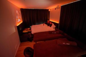 a person sitting on a bed in a small room at Exclusieve privé wellness penthouse SkyNooz in Antwerp +52 photos