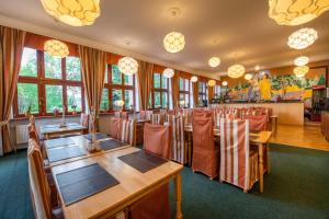 a restaurant with wooden tables and chairs and windows at Miramonti Penzión in Vysoke Tatry - Horny Smokovec