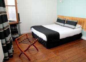 a bedroom with a bed and a chair in it at Hotel Ultramar in Valparaíso