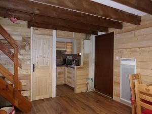 eine Küche mit Holzwänden und eine Tür in einem Zimmer in der Unterkunft CAP DES NEIGES 1 in Barcelonnette