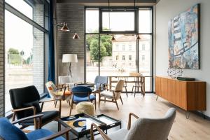 a living room with chairs and tables and a large window at FREIgeist Göttingen Innenstadt, A Member of Design Hotels in Göttingen