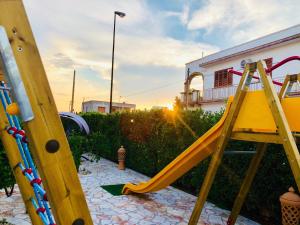 un parco giochi con scivolo in un cortile posteriore di B&B NiloSira a Morciano di Leuca