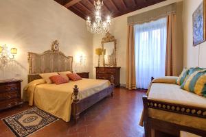 a bedroom with two beds and a chandelier at Palazzo Bucciolini in Florence