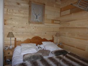 ein Schlafzimmer mit einem Bett in einem Blockhaus in der Unterkunft CAP DES NEIGES 1 in Barcelonnette