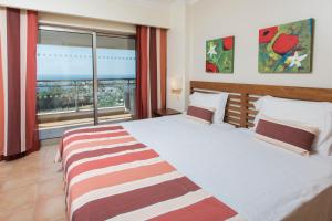 a bedroom with a large bed with a large window at Alfagar Alto da Colina in Albufeira
