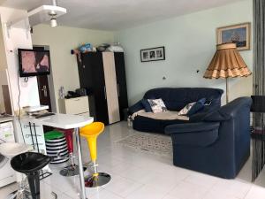 a living room with a blue couch and a table at Alice Apartment in Obzor