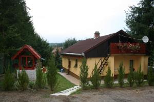 una pequeña casa amarilla con techo rojo en Sasvár Vendégház, en Parádsasvár